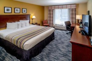 a hotel room with a bed and a flat screen tv at Country Inn & Suites by Radisson, Charleston South, WV in Charleston
