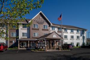 una vista frontal de un hotel del condado con bandera americana en Country Inn & Suites by Radisson, Charleston South, WV en Charleston