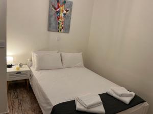 ein kleines Schlafzimmer mit einem Bett und einem Gemälde einer Giraffe in der Unterkunft Home in nature in Michalítsion