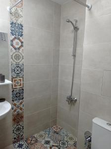 ein Bad mit Dusche, WC und Fliesen in der Unterkunft Комплекс Падалото "ЕТНО" in Smoljan