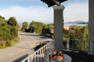 a balcony with a table and a view of a street at Pyrgi house, Ipsos Corfu in Ipsos