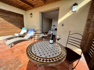 a table with a bottle of wine on a patio at Hôtel U San Daniellu villas et chambres in Saint-Florent +29 photos