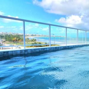 a swimming pool with a view of the ocean at Paradise by Hosppedar in João Pessoa