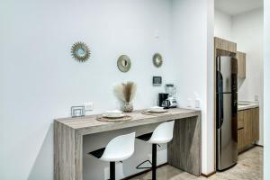 - une cuisine avec un comptoir avec deux chaises et un réfrigérateur dans l'établissement The Perfect Place, Unit 005, à Playa del Carmen 6 autres photos