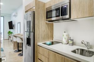 uma cozinha com um frigorífico de aço inoxidável e um lavatório em The Perfect Place, Unit 005 em Playa del Carmen