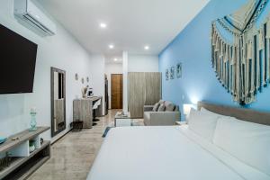 a hotel room with a large bed and a tv at The Perfect Place, Unit 005 in Playa del Carmen