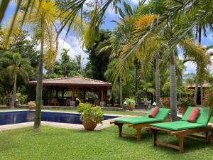 a yard with two chairs and a swimming pool at Avalon Village Resort in Induruwa