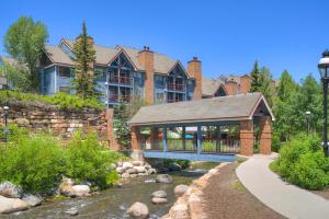 a large house with a bridge over a river at River Mountain Lodge by Breckenridge Hospitality in Breckenridge