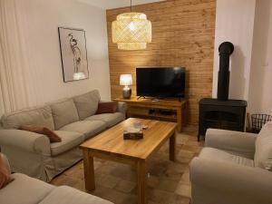 米科瓦伊基的住宿－Stare Sady 25 EA，带沙发、桌子和电视的客厅