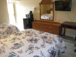 Schlafzimmer mit einem Bett, einer Kommode und einem Spiegel in der Unterkunft Relax Inn in Rome