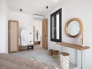 1 dormitorio con espejo y vestidor en Athina Milos Suites, en Adamas
