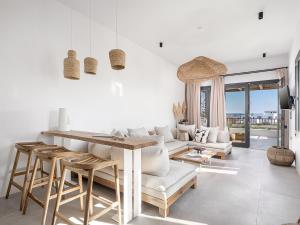a living room with white furniture and a table at Athina Milos Suites in Adamantas