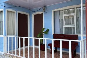 a blue house with a bench and a window at Casa Vista Cafe in Cartago