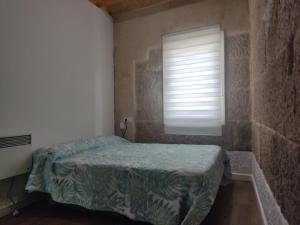 a small bedroom with a bed and a window at Pleno Casco Vello, Céntrico, Reformado 2023 in Vigo
