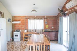 eine Küche mit einem langen Holztisch in einem Zimmer in der Unterkunft La Mora Cabañas in Villa Urquiza + 31 Fotos