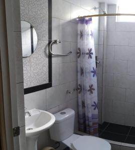 y baño con lavamanos y cortina de ducha. en Hostal Bryana Inn Baños en Baños