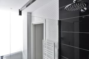 W łazience znajduje się lustro oraz ściany wyłożone czarno-białymi kafelkami. w obiekcie Lata Luxury Rooms w Rzymie