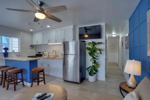 a kitchen with white cabinets and a refrigerator at Catalina Island Duplex - Steps to Beach and Pier! in Avalon