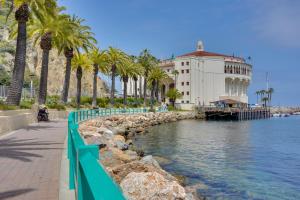 um edifício ao lado de um corpo de água com palmeiras em Catalina Island Duplex - Steps to Beach and Pier! em Avalon