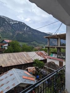 a balcony of a building with a view of a mountain at Krishna Guesthouse by AttiC Monkey, Old manali next to Drifters cafe in Manāli