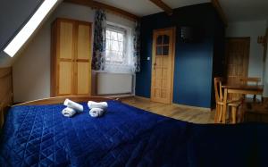 due asciugamani su un letto blu in una camera da letto di Pokoje Gościnne u Jonka a Zakopane