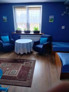 a blue room with couches and a table and a window at Zgorzanka in Istebna