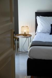 een slaapkamer met een bed en een tafel met een lamp bij Cassari 61 in Palermo