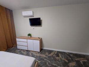 1 dormitorio con 1 cama y TV en la pared en Сучасні апартаменти Палац Спорту, en Járkov