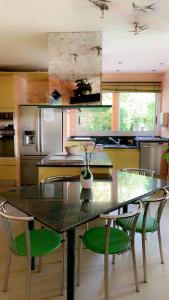 una cocina con una mesa con sillas y un jarrón con flores en Le Domaine de Charline de 1 à 35 personnes, en Issel
