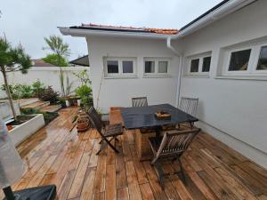 un patio con mesa y sillas en una terraza de madera en Jolie SUITE de 28m² - LA HUME Centre, en Gujan-Mestras