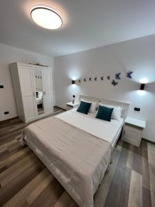 ein Schlafzimmer mit einem großen weißen Bett mit blauen Kissen in der Unterkunft Sunny Luxury Home G. Enescu in Suceava