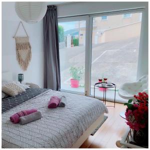 een slaapkamer met een bed en een groot raam bij Rooms Dora in Ičići