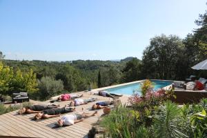 a group of people laying on a deck next to a swimming pool at Idyllic French farmhouse in Les Assions