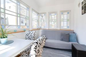 ein Wohnzimmer mit einem Sofa und Fenstern in der Unterkunft Kierunek Sopot Apartament WERANDA Haffnera 32 in Sopot + 22 Fotos