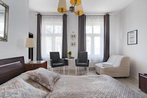 ein Schlafzimmer mit einem Bett und zwei Stühlen und einem Tisch in der Unterkunft Kierunek Sopot Apartament WERANDA Haffnera 32 in Sopot