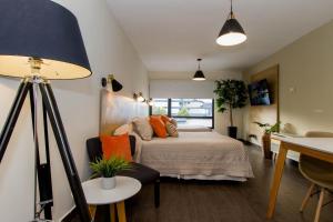 een slaapkamer met een bed met oranje kussens bij Rivadavia Apartamentos in Ushuaia