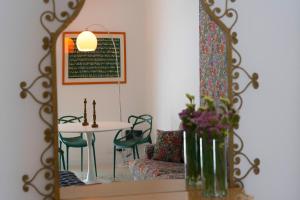een eetkamer met een tafel en een spiegel bij Cassari 61 in Palermo