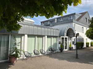 un groupe de chaises assis à l'extérieur d'un bâtiment dans l'établissement Premium Apartments Koblenz, à Coblence