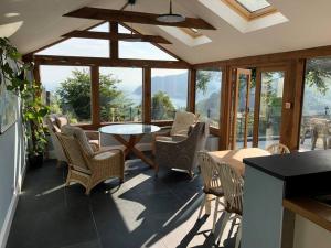 a patio with chairs and a table and windows at Spacious 4-Bed House in Lynton in Lynton