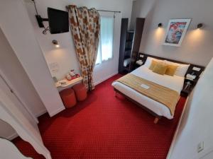 - une chambre avec un lit et un tapis rouge dans l'établissement Cit'Hotel Les Atlantes, à Médis