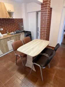 a kitchen with a wooden table and four chairs at Apartament SweetHome Piața Unirii in Iaşi
