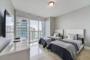 マイアミにあるWonderful 2 BR Condo Icon Brickell With Poolのベッドが2つと大きな窓がある寝室 +18枚の写真