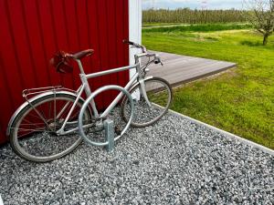 a bike parked next to a red building at Muggelhuus das Loft mit Elbdeichblick im Alten Land und mit Wallbox in Twielenfleth