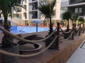 una terraza de madera con una soga y palmeras en Apartament 105 - HF Building Resort, en Mamaia Nord – Năvodari