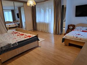 ein Schlafzimmer mit zwei Betten und einem Teddybär darin in der Unterkunft Casa din livada in Borşa
