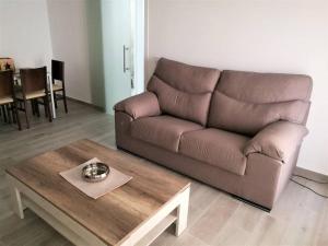 uma sala de estar com um sofá castanho e uma mesa de centro em Apartamento céntrico en Palamós em Palamós