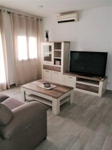 uma sala de estar com um sofá e uma televisão em Apartamento céntrico en Palamós em Palamós