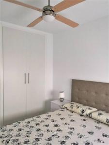 1 dormitorio con 1 cama y ventilador de techo en Apartamento céntrico en Palamós en Palamós
