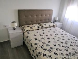 a bedroom with a bed with a black and white comforter at Apartamento céntrico en Palamós in Palamós