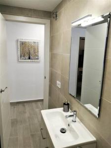uma casa de banho com um lavatório e um espelho em Apartamento céntrico en Palamós em Palamós